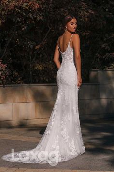 a woman in a wedding dress is standing on the sidewalk and looking at something behind her