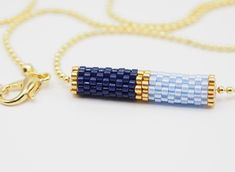 a blue and white beaded tube necklace on a gold filled chain with a lobster hook clasp