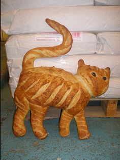 a cat made out of bread sitting on the ground