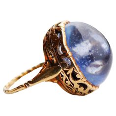 Luxurious Antique Ring in Renaissance style, band and crown tested solid 18K Gold,not hallmarked, European, ca. XVIII - early XIX centuries. Huge cabochon of natural Light - Blue Sapphire measuring 16,69 mm x 12.2 mm x 10.7 mm deep /ca. 25 ct, most likely of Ceylon origin. Beautifully cut and polished stone, untreated, with numerous inclusions, one of a kind. I got this ring with the stone sitting tightly in its bezel and after examination, I became curious about its true size, the nature of its Luxury Antique Cabochon Sapphire Ring, Formal Gold Oval Cabochon Sapphire Ring, Gold Oval Cabochon Sapphire Ring For Formal Occasions, Gold Sapphire Ring With Oval Cabochon For Formal Events, Formal Gold Sapphire Ring With Oval Cabochon, Formal Yellow Gold Cabochon Sapphire Ring, Formal Yellow Gold Domed Sapphire Ring, Vintage Oval Cabochon Sapphire Ring For Formal Occasions, Antique Cabochon Sapphire Ring