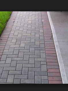 the sidewalk is lined with bricks and grass