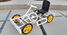 a white and yellow cart sitting on top of a parking lot next to a black chair