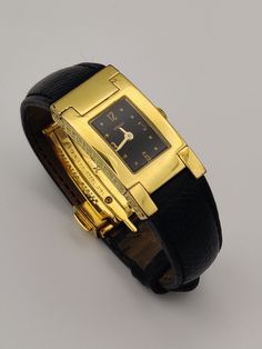 Stunning vintage Versace watch, with a gold plated dial, leather strap engulfing a deployment clasp closure.  In working order. Has minor wear on, please see pictures.  Length: 14cm. Measured internally while clasp is closed.  Dial width: 1.7cm Luxury Business Watches With Gold Clasp, Designer Leather Watch Accessories For Formal Occasion, Gold Watch Bands With Rectangular Dial For Formal Occasions, Luxury Gold Evening Watch, Modern Formal Watches With Gold-tone Hardware, Gold Leather Strap Watch Band For Business, Luxury Gold Watch With Leather Strap, Luxury Gold Watch Bands For Business, Timeless Evening Watch With Gold Clasp