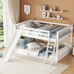 a white bunk bed with a slide in the middle and pillows on the bottom floor