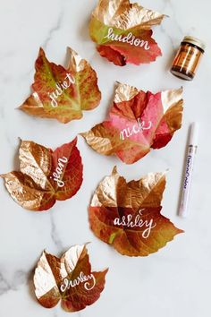 some leaves that have been painted gold and red with the words autumn written on them