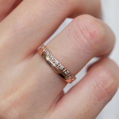 a woman's hand with a gold wedding band and diamond set in the middle