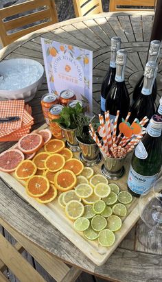 a table topped with bottles of wine, oranges and other food on top of it