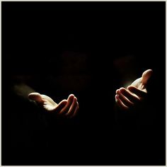 two hands reaching out towards each other in the dark