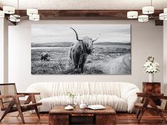 a cow standing in the middle of a living room next to a table and chairs