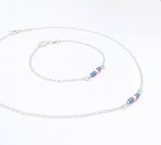 "Handmade sterling silver jewellery set. Necklace och bracelet. Dainty acrylic beads making up the transgender pride flag. Delicate silver chain. Sizing instructions: Necklace: Order at least 2.5 cm (1\") longer than the intended wearers neck for a tight fit. Longer for a looser fit. Bracelet: Order 1.5 cm (1/2\") longer than the intended wearers wrist for a proper fit. Stand alone bracelet: https://www.etsy.com/listing/1012672163 Stand alone necklace: https://www.etsy.com/listing/998700534 This Sterling Silver Necklace With Spacer Beads As Gift, Dainty Sterling Silver Jewelry With Spacer Beads, Gift Sterling Silver Necklace With Spacer Beads, Minimalist Polished Beads Jewelry As A Gift, Minimalist Silver Beads Jewelry As Gift, Minimalist Silver Beads Jewelry Gift, Minimalist Polished Bead Bracelet, Minimalist Silver Beaded Jewelry As A Gift, Dainty Silver Jewelry With Polished Beads