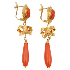 A fine and impressive pair of vintage coral and 18 karat yellow gold drop earrings. Each articulated earring features a signature torpedo-shaped coral drop. The coral drop is crowned with a yellow gold bow and hangs from an oval-shaped engraved coral relief. These vintage earrings are each embellished with a coral cut-out design at the top, featuring a woman in profile. The gold around the carved coral is created in a floral pattern. The earrings are in very good condition and of high quality, a Woman In Profile, Yellow Gold Drop Earrings, Coral And Gold, Cut Out Design, Gold Drop Earrings, Early 20th Century, Vintage Earrings, Jewelry Earrings Dangle, 20th Century