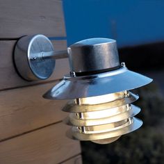 a light that is on the side of a building next to a wooden wall and door