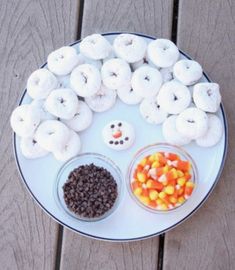 a white plate topped with donuts covered in frosting next to candy corn and chocolate chips