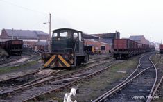 there is a train that is on the tracks next to other railroad tracks and buildings