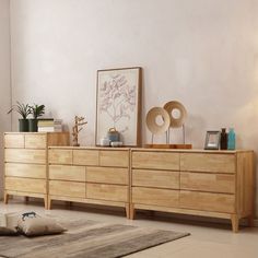 a wooden dresser sitting on top of a white floor next to a rug and lamp