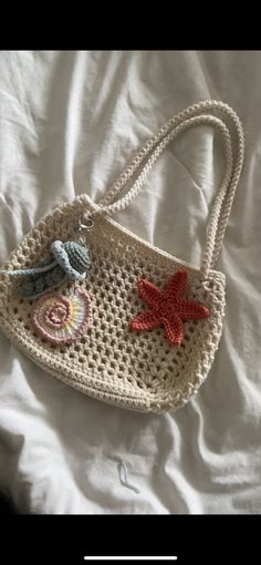 a crocheted handbag with two starfishs and seashells on it