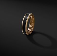 a gold wedding ring on a black background