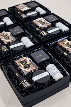 four black boxes filled with different types of perfumes and cologne bottles on top of each other