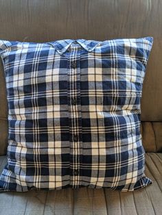 a blue and white plaid pillow sitting on top of a couch