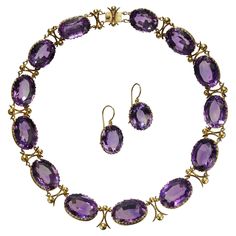 An antique amethyst and gold riviére necklace and earrings suite, with large, oval faceted, graduated amethysts, in open backed decorative, trefoil design, gallery strip bezel settings, with curved cross and ball links between the amethysts, with a gold box and tongue clasp, with matching drop earrings, on gold wires, circa 1880. Estimated total weight of amethysts in the necklace 259.99 carats and in the earrings 28.22 carats. Some of the earliest examples of amethyst jewellery are seen in work Amethyst Rock, Moonstone Drop Earrings, Amethyst Set, Diamond Cluster Earrings, Amethyst Gold, Bee Pendant, Gold Box, Amethyst Jewelry, White Gold Earrings