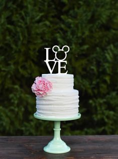 a white wedding cake sitting on top of a wooden table