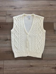 I love this vintage ladies sweater vest!  It's such a classic!  It's a buttery cream acrylic fabric in a cable design.  It's by Alfred Dunner, who I usually find to have an old-fashioned vintage look even in modern times.  Often their current pieces look like vintage styles, but this one is from the 70s 80s made in Taiwan.  It's a size Small.  Pretty roomy, please see measurements below.  It has a preppy vibe and definitely fits into the menswear look that is popular today.  It's in very nice condition!  You can see some rubbing/fuzzing to the acrylic, but overall the vest shows well.  Acrylic is prone to that.  I love this quintessential sweater vest!  Thanks for looking! Measurements taken laying flat: please double for chest & waist Armpit to armpit 19" Waist/middle 18.5" Length 23.5" Cozy Fitted Cable Knit Sweater Vest, Fitted White Cable Knit Sweater Vest, Cream Cotton Sweater Vest For Winter, Fitted Cotton Cable Knit Sweater Vest, Fitted Cable Knit Vest, Classic Cotton Cable Knit Sweater Vest, Classic White Knit Sweater Vest, Fitted Beige Cable Knit Sweater Vest, Cream Fitted Sweater Vest For Winter