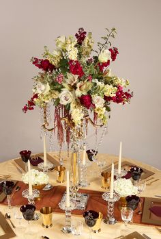 the table is set with candles, flowers and wine glasses for an elegant centerpiece