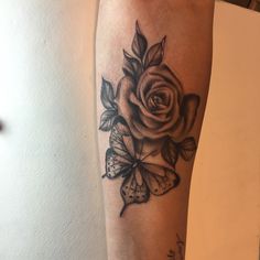 a rose and butterfly tattoo on the arm