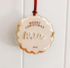 a wooden christmas ornament hanging from a door with the word merry christmas aera on it