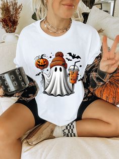 The Ghost Coffee and Pumpkin Unisex Softstyle T-Shirt combines comfort and style for a casual yet trendy look. Soft and Comfortable: Made from very soft 100% cotton for solid colors, this t-shirt ensures maximum comfort all day long. Versatile: The unisex design makes it perfect for both men and women, adding versatility to your wardrobe. Fashionable Design: The unique ghost coffee and pumpkin design adds a touch of style to your everyday outfit. The shoulder-to-shoulder taping enhances the durability of the shirt while providing a comfortable fit. Available in heather colors or sports grey with added polyester, this t-shirt is perfect for any occasion - whether it's running errands or hanging out with friends. Elevate your casual wear with the Ghost Coffee and Pumpkin Unisex Softstyle T-S Casual Halloween T-shirt, Coffee Color Long Sleeve Graphic T-shirt, Coffee Long Sleeve T-shirt With Graphic Print, Coffee Color Long Sleeve T-shirt With Graphic Print, Casual Coffee Crew Neck T-shirt, Casual Long Sleeve Coffee T-shirt, Casual White T-shirt For Fall, Coffee Crew Neck Graphic T-shirt, Coffee Graphic Tee With Crew Neck