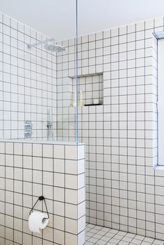 a bathroom with white tiled walls and floor