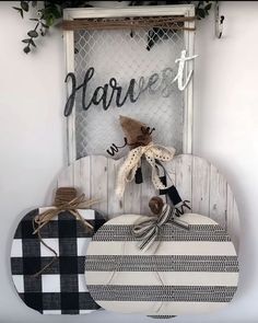 a wooden sign that says harvest next to a black and white plaid table cloth covered board