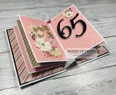 a close up of a folded card on a wooden surface with the number 65 printed on it