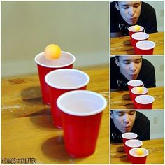 a boy is playing with red cups and an orange ball