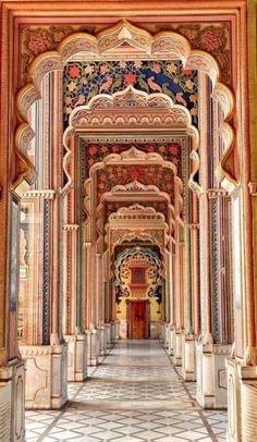 an intricately decorated hallway in the middle of a building with columns and arches on either side