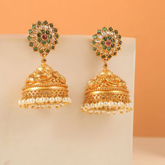 Step into the spotlight with our simply stunning antique earrings! Crafted with intricate peacock motifs in embossed antique gold-plated metal and adorned with sparkling cubic zirconia stones, these earrings are a true masterpiece. Be prepared for compliments as you showcase the perfect blend of craftsmanship and style. Ornate Brass Jhumkas For Wedding, Ornate Kundan Jhumkas As Gift, Ornate Chandbali Jhumkas As Gift, Heavy Ornate Jhumkas As Gift, Ornate Heavy Jhumkas As Gift, Ornate Heavy Jhumkas For Gift, Ornate Heavy Jhumkas For Festive Occasions, Ornate Kundan Jhumkas, Ornate Brass Chandbali Jhumkas