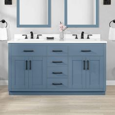 a bathroom vanity with two sinks and mirrors