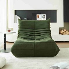 a green bean bag chair sitting on top of a white rug in front of a fireplace