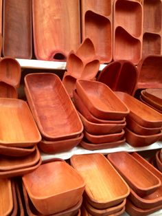 many wooden plates and bowls are stacked on top of each other