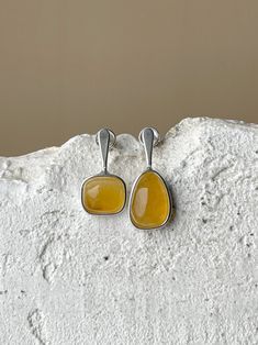 The earrings are our basic model and bestseller, as they are perfect for everyday looks. All the inserts in geometric shapes are meticulously selected by the designer. This is precisely why they harmonize so seamlessly and unveil a spectrum of amber's hues. The asymmetry of this model not only allows us to treat the stone with heightened care during processing but also reflects our commitment to minimizing waste. The jewelry is presented in a unique piece. Weight 0,10 oz Length 0,98" Amber Earrings, Mismatched Earrings, Amber Jewelry, Light Weight Earrings, Geometric Earrings, Earrings Collection, Sterling Silver Earrings Studs, Silver Earrings Studs, Silver Studs