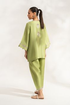 Siran (B) reinterprets the classic shalwar kameez with its box cut front open pure rawsilk shirt in a sage green hue. The subtle combination of ivory, lavender, and lilac embroidery elevates the shirt and the hem of the pure rawsilk shalwar.Model Height: 5'6 Length: 29" Formal Long Sleeve Palazzo Set With Naqshi Embroidery, Formal Long Sleeve Palazzo Set With Naqshi Detail, Formal Long Sleeve Palazzo Set With Naqshi, Naqshi Palazzo Set For Eid, Formal Naqshi Palazzo Set For Eid, Formal Green Lawn Suit With Dabka Work, Green Palazzo Set With Embroidered Border For Wedding, Wedding Green Palazzo Set With Embroidered Border, Green Palazzo Set With Embroidered Border For Eid