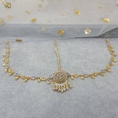 Absolutely stunning Gold and Silver Borla Mathapatti. The classic combination of gold and Silver. The matha Patti is studded with clear stones, strung together with soft studded chain. Matching drops have been added to finish the look. Beautiful piece. It Gives you a pure royal look, Ideal for Mehandi, weddings, and parties.  Please read our shop policies before making a purchase.  Drop Lenth 13cm Tikka Width: 3cm We try to take photos as natural as we can but color can be slight variations due to lighting  Jewelry Care -- Keep all the jewelry away from water, perfumes, and other harsh chemicals To clean wipe with a lint-free cloth to retain the shine Gold Bridal Sets With Hand Set Crystals, Gold Cubic Zirconia Jewelry For Festivals, Gold Bollywood Style Round Tikka, Gold Round Bollywood Tikka, Gold Temple Jewelry Bridal Necklace With American Diamond, Gold Temple Style Bridal Necklace With American Diamonds, Gold Bridal Necklace With American Diamond In Temple Style, Gold Plated Rhinestone Jewelry For Wedding, Gold Round Tikka For Festive Occasions