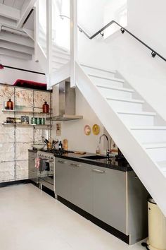 a kitchen with stainless steel appliances under a stair case