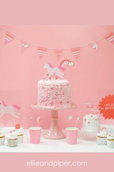 a pink unicorn themed birthday party with cupcakes and cake on a table in front of a pink wall