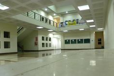 an empty building with white walls and floors, some signs on the balconies