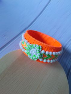 Amazing bracelet for her, Original jewelry gift for girlfriend, Neon colors bijouterie for rave party, Floral cool present for young sister Absolutely stunning and beautiful bracelet with handwoven tape in the incredible neon orange and green colors.  Bracelet is decorated with beautiful white crochet roses and white beads.  Perfect gift for every woman or girl and even for men beacause jewelry is gender neutral :) The bracelet is so beautiful that it fits with any outfit - elegant or everyday d Handmade Orange Cuff Bracelet Gift, Green Jubilee Bracelet As A Gift, Green Jubilee Bracelet Perfect As A Gift, Orange Beaded Bangle Bracelet As Gift, Handmade Bracelet Wristlet For Gifts, Green Bangle Friendship Bracelets, Handmade Orange Cuff Bracelet Bangle, Handmade Bangle Bracelets As Gift For Her, Handmade Wristband For Gift