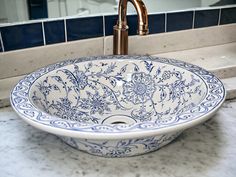 a blue and white bowl sink sitting on top of a counter next to a faucet