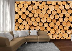 a living room with couches and wooden logs on the wall in front of it