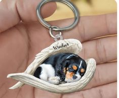 a hand holding a keychain with a dog in it