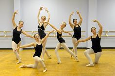 a group of young ballerinas in black leotards posing for the camera